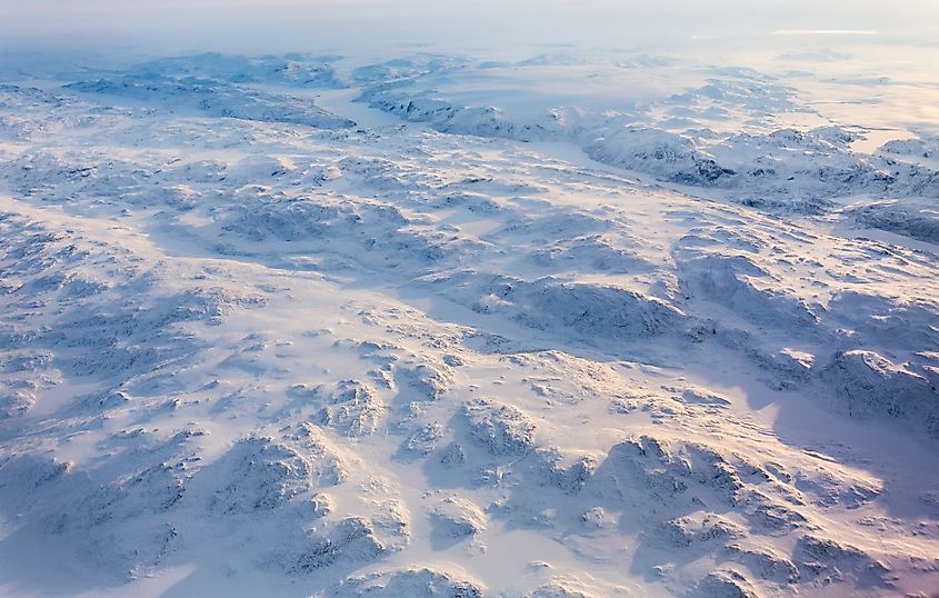 Greenlandic ice cap with frozen mountains and fjords aerial view, near Nuuk, Greenland. Via Shutterstock / vadim_m