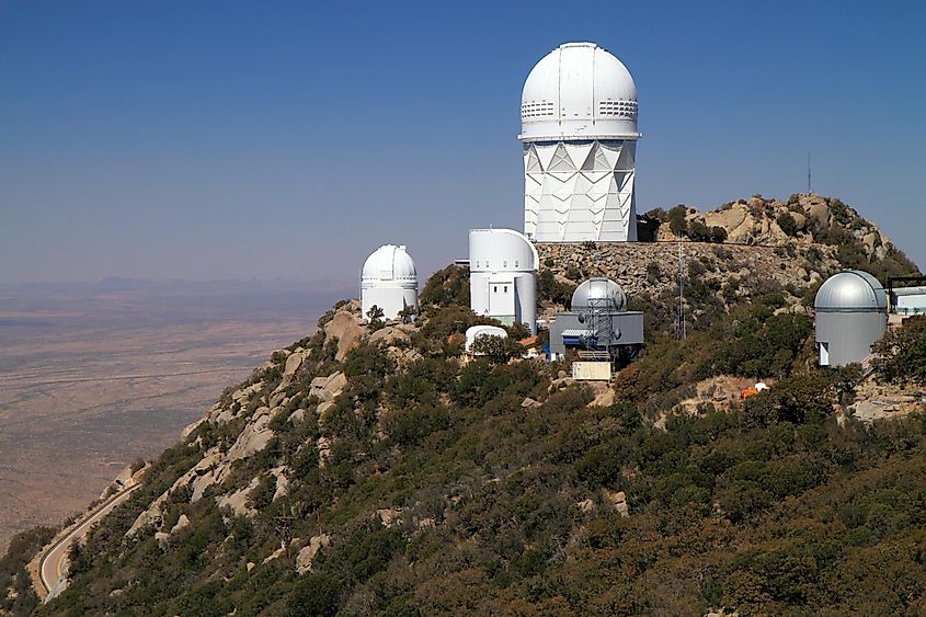 The white domes of Kitt Peak National Observatory on a rocky Arizona summit, with the tall Mayall Telescope dome at the top