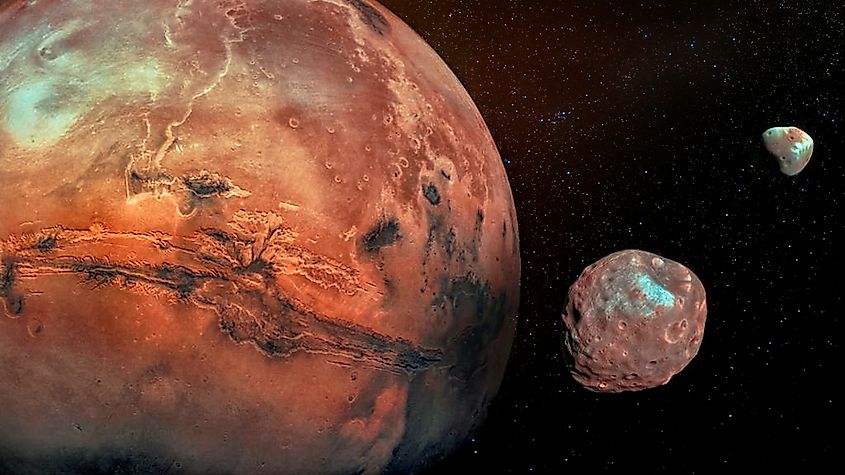 Mars with its two cratered moons, Phobos and Deimos. Elements of this image furnished by NASA.