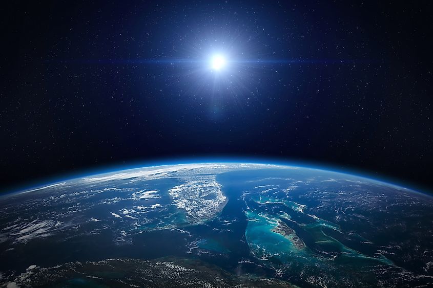 Deep space showing Earth, a galaxy, and scattered stars against a black background.