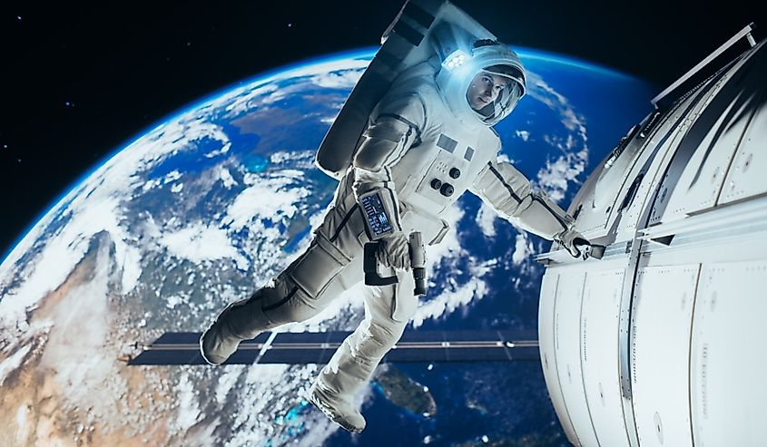 An astronaut in a white spacesuit conducting a spacewalk outside the International Space Station.