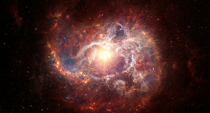 A dark night sky with a red star and a distant galaxy against black space.
