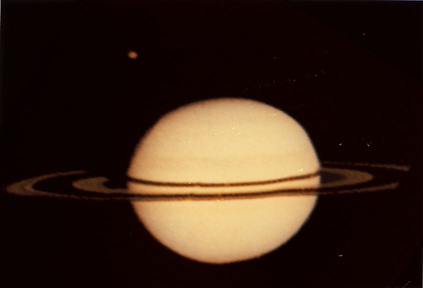 NASA's Pioneer 11 image of Saturn and its moon Titan at the upper left. Editorial credit: NASA, Public Domain, https://commons.wikimedia.org/w/index.php?curid=650662